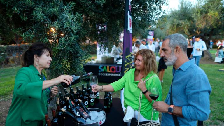 Una pareja llena sus copas con un vino tinto de una de las bodegas participantes . foto: ALBA MARINÉ