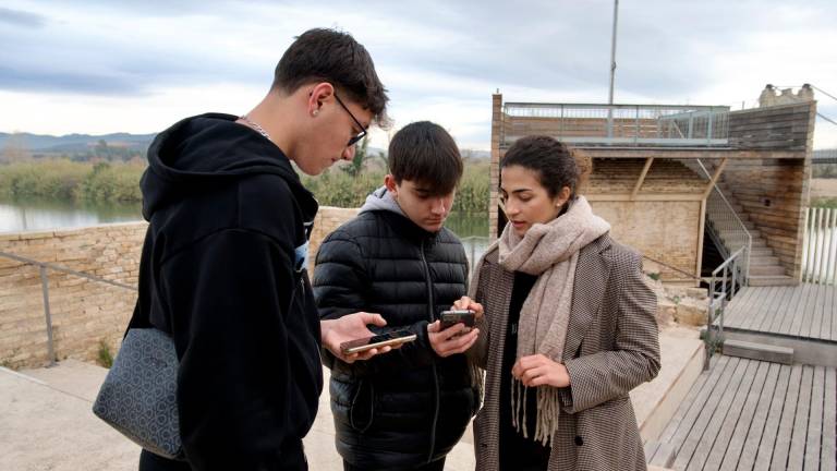 Dos joves amb l’autora de l’aplicació al telèfon mòbil. Foto: Joan Revillas