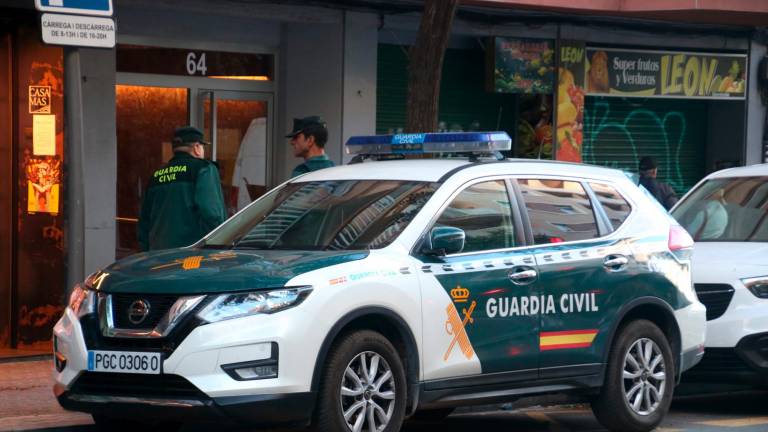 Dos agentes delante de un bloque de la avenida Ramón y Cajal de Tarragona, hoy. Foto: ACN