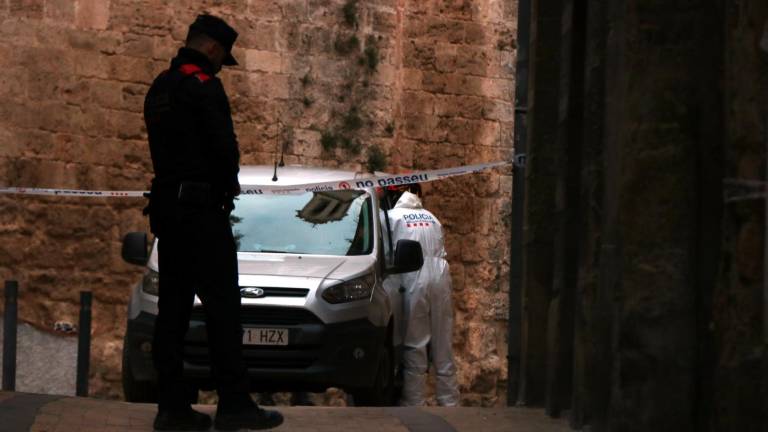Un agente de la Policía Científica –vestido de blanco– ayer delante de la casa donde se halló el cadáver. Foto: ACN
