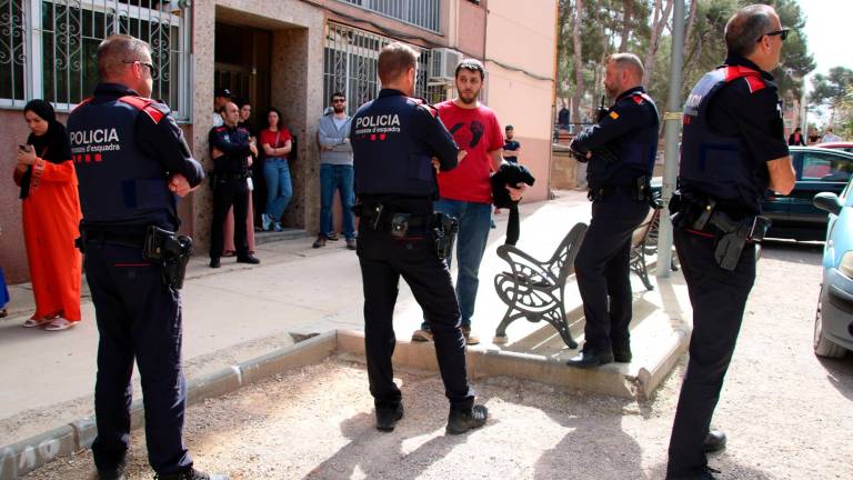 La comitiva judicial hablando con la mujer que tenía que ser desahuciada en el barrio de Sant Salvador y agentes de los Mossos d’Esquadra. Foto: ACN