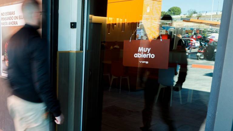 Un cliente accede a un restaurante que cuenta con un sistema de cierre de puertas automático, este viernes en Madrid. Foto: Efe