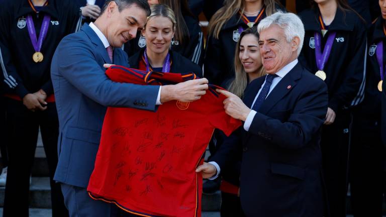 El presidente del Gobierno, Pedro Sánchez (i), observa la camiseta firmada entregada por el presidente de la Comisión Gestora de la RFEF, Pedro Rocha. Foto: EFE