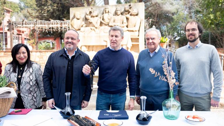Alberto Núñez Feijóo cogiendo por p`rimera vez un calçot, este domingo 9 de marzo en Masia Bou, en Valls. FOTO: Alba Mariné
