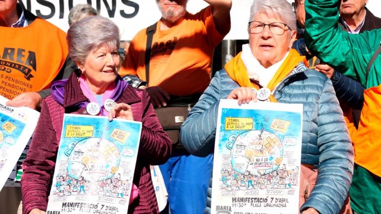 Dos miembros de Marea Pensionista de Catalunya mostrando el cartel que anuncia la manifestación de este domingo, 7 de abril, en el marco del Día Mundial de la Salud. FOTO: Norma Vidal / Maria Pratdesaba