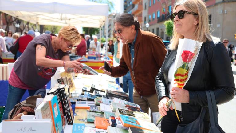 Una mujer con su rosa y un hombre comprando un libro. Foto: Àngel Ullate