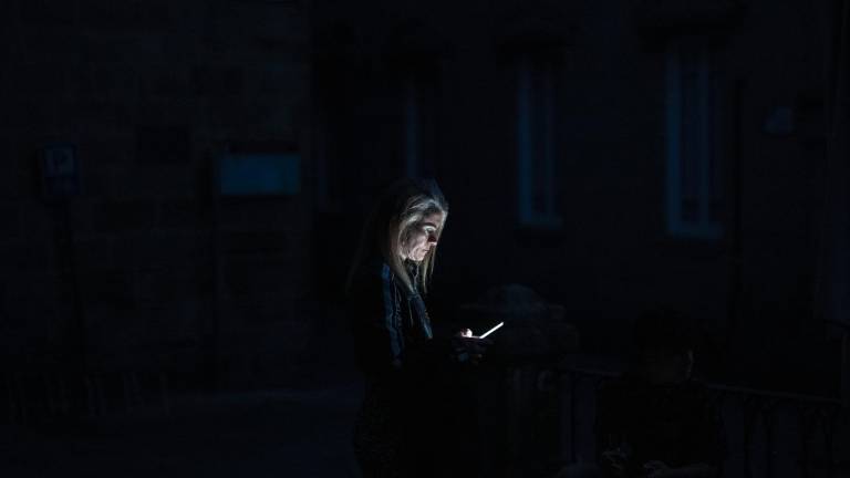 Una mujer consulta su teléfono móvil durante el apagón eléctrico en Ourense. Foto: EFE