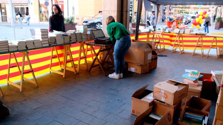 Júlia Albesa, de la llibreria La Irreal de Tortosa atén la primera clienta de Sant Jordi a la seva parada. Foto: ACN
