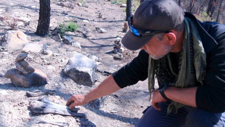 Esteve Corbella mostra les restes òssies de combatents de la batalla de l’Ebre trobades a la zona cremada. Foto: ACN
