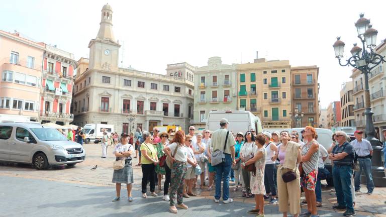 Visitantes de una ruta guiada en la plaza del Mercadal de Reus, estos días. Foto: Alba Mariné