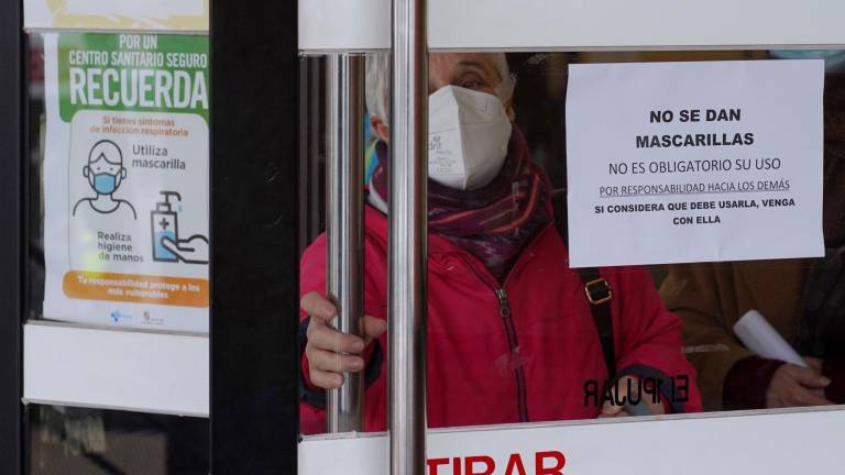 Una mujer sale de un centro de salud en Valladolid, en el que se pueden leer distintos carteles sobre el uso de la mascarilla, este miércoles. Foto: EFE