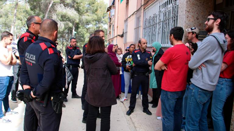 Agentes de los Mossos d’Esquadra hablando con uno de los miembros del Sindicat d’Habitatge de Tarragona durante la mediación hecha para parar un desahucio de una familia al barrio de Sant Salvador. Foto: ACN