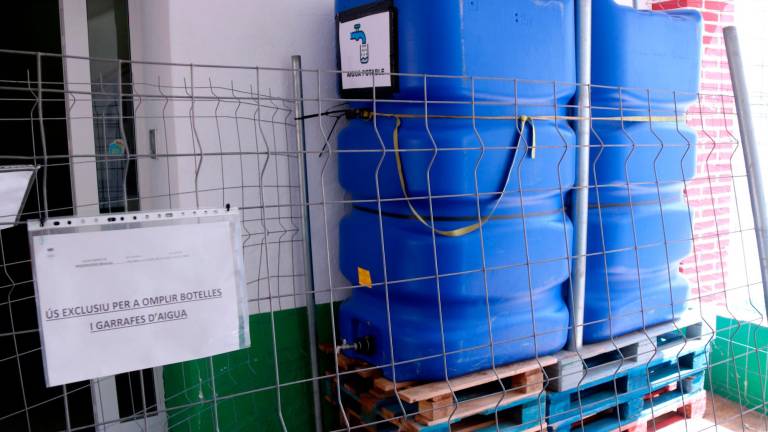 Dipòsits provisionals d’aigua potable instal·lats al porxo de l’Ajuntament de Masdenverge per donar servei al veïnat. Foto: ACN