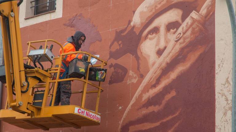 L’artista urbà Roc BlackBlock pintant la façana de l’Alberg, situat al nucli de les Masies. foto: cedida