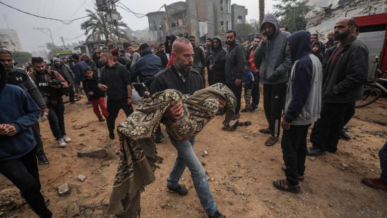 Un hombre palestino carga con el cuerpo de una joven tras un ataque. Foto: EFE