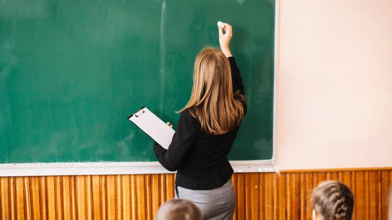 Una profesora escribe en la pizarra, en una foto procedente de un banco de imágenes. FOTO: FREEPIK