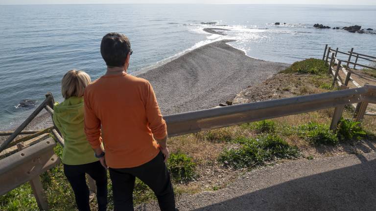 Una parella contempla la barra de còdols que s’endinsa a la mar.FOTO: JOAN REVILLASIMATGE AÈRIA DE SÒL DE RIU QUAN EL ‘DELTA’ ERA MÉS VISIBLE.FOTO: GREG SOBIERAJ