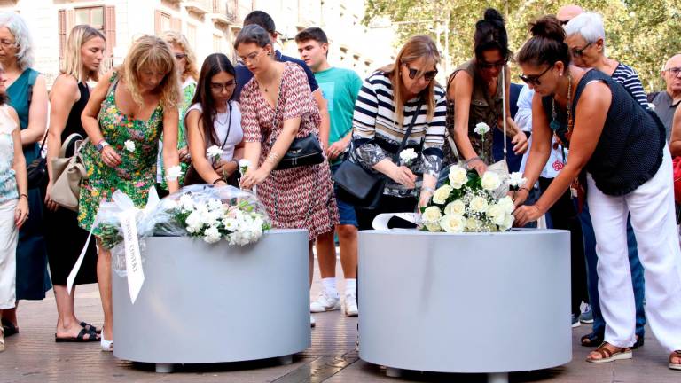 Momento en que los familiares y víctimas han depositado las flores en las jardineras de la Rambla. Foto: ACN