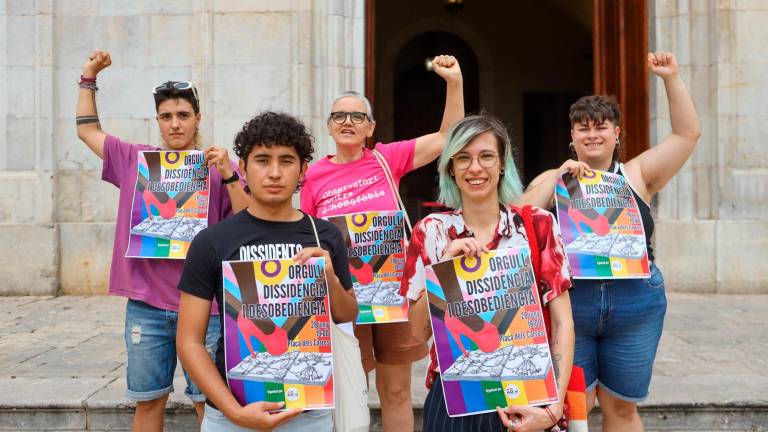 Algunos de los organizadores de la manifestación con el cartel de este año. Foto: Alba Mariné