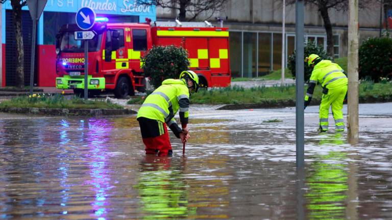 Bomberos trabajan en una vía inundada, por el paso de la borrasca Karlotta, este viernes en Santiago de Compostela. Foto: EFE