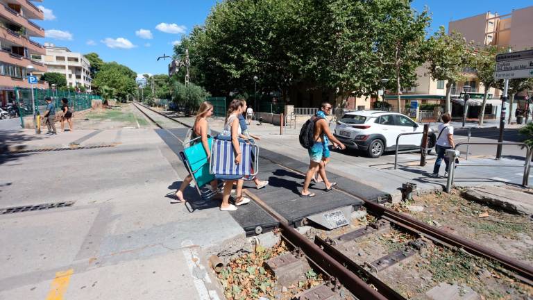 Turistas cruzando por el antiguo paso a nivel de la calle Barcelona, uno de los últimos tramos donde se desmantelará la vía. Foto: Alba Mariné