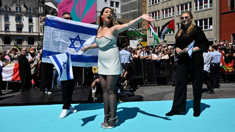 La representante de Israel en Eurovisión, Yuval Raphael, entre banderas israelíes y palestinas, en un acto promocional del festival en Basilea, Suiza. FOTO: EFE