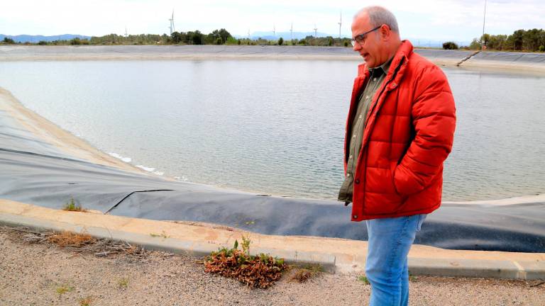 Un trabajador de la comunidad de regantes junto a una balsa en la Fatarella. Foto: Anna Ferràs/ACN