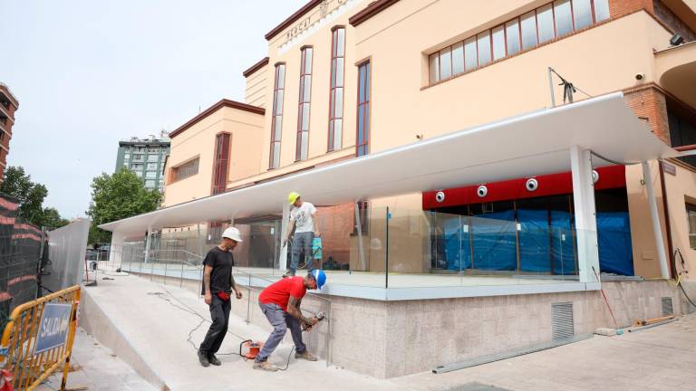 Operarios ultimando detalles de la reforma de la fachada principal del Mercat Central, por la calle Sant Joan. FOTO: Alba Mariné
