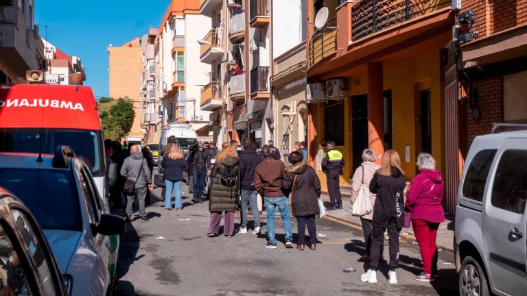 Vecinos, efectivos sanitarios y fuerzas de seguridad en la calle junto al bloque de viviendas de la calle Villanueva de los Castilleja, en la barriada de Isla Chica en Huelva donde han fallecido tres jóvenes. Foto: EFE