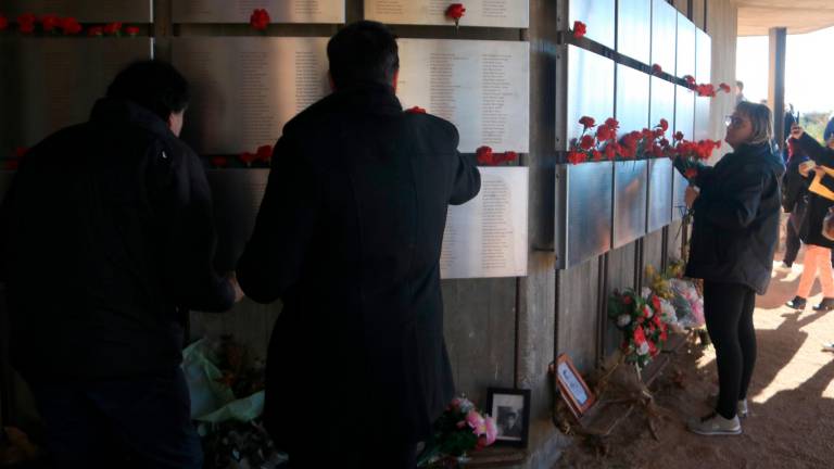 Diverses persones col·loquen clavells al Memorial de les Camposines de la Fatarella. Foto: ACN.