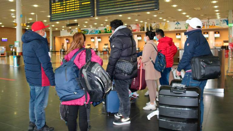 $!Un grupo de pasajeros miran el tablero de salidas en el aeropuerto de Reus. Foto: Eloi Tost / Núria Torres (ACN)