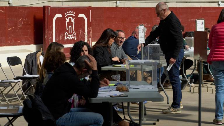 Un hombre ejerce su derecho al voto en el Iradier Arena, que antes era una plaza de toros detrás de una mesa electoral durante las elecciones vascas, este domingo. Foto: EFE