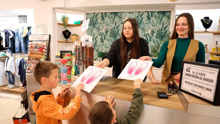 Dos niños encuentran los huevos de Pascua escondidos en una tienda de Salou. Foto: Alba Mariné