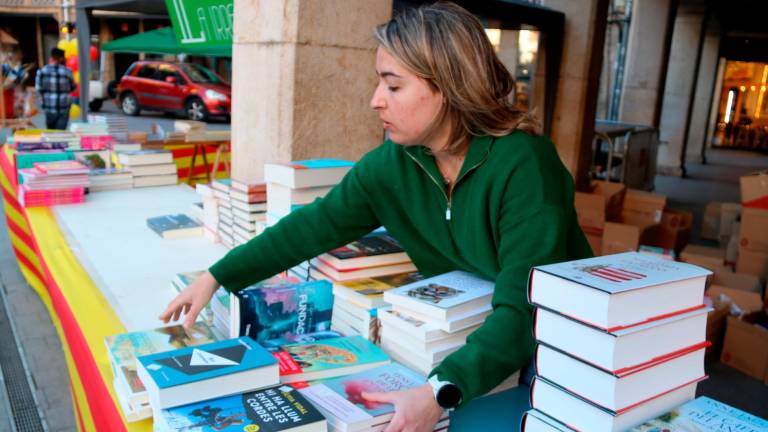 Júlia Albesa, de la Irreal de Tortosa, col·loca llibres a la parada de Sant Jordi. Foto: ACN