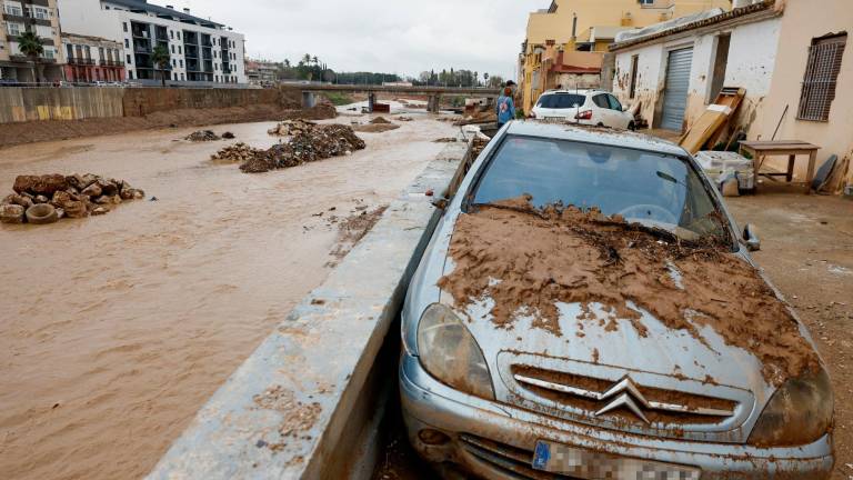 Vehículos cubiertos de barro e inmuebles destrozados junto al barranco del poyo. Foto: EFE