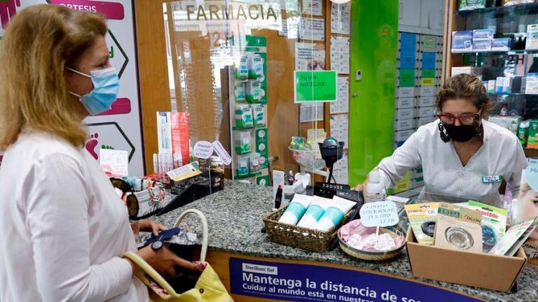 Una mujer y una dependienta de una farmacia de Madrid. Foto: EFE/Chema Moya