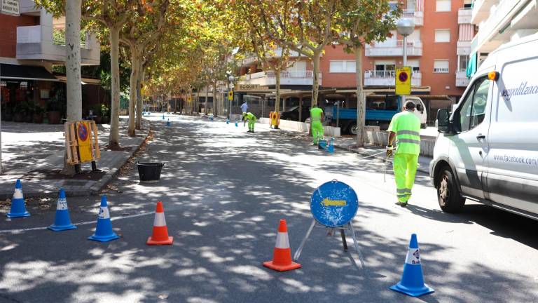 Operarios trabajando en las marcas del pavimento que delimitan el nuevo espacio destinado para la circulación de peatones. Foto: Alba Mariné