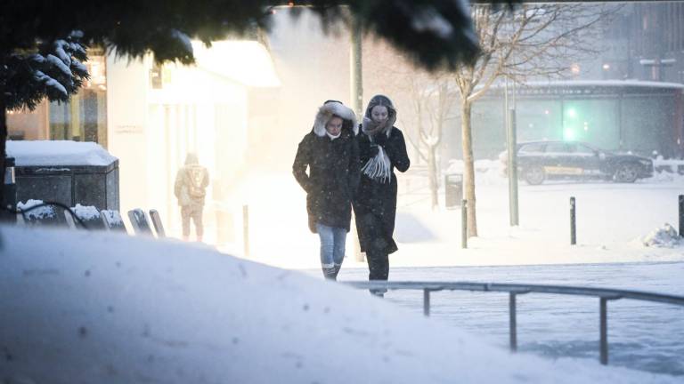 Dos personas caminan en medio de una calle nevada de Helsinki, después de una fuerte tormenta de nieve que ha afectado al sur de Finlandia. Foto: EFE/KIMMO BRANDT