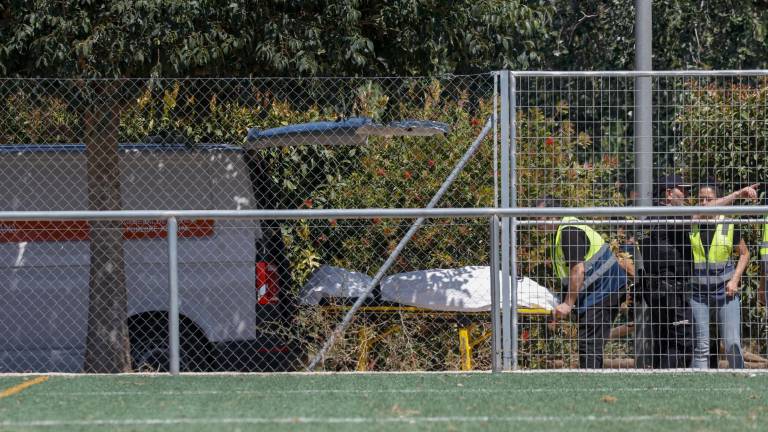 Miembros del retén fúnebre trasladan el cadáver del menor de unos 11 años que desapareció este jueves cuando se bañaba en el río Júcar, a su paso por la localidad valenciana de Alzira, tras haber sido localizado este viernes. Foto: EFE