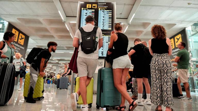 Numerosas personas hacen cola en la zona de facturación de la T-3 del Aeropuerto de Palma. Foto: EFE