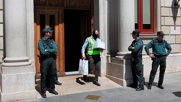 Un agente de la Guardia Civil sacando documentos del Ayuntamiento de Reus sobre el Caso Innova. Foto: Alba Mariné/DT