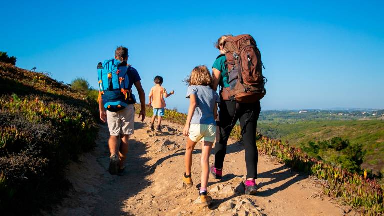 El ejercicio físico, del tipo que sea, es beneficioso para nuestra salud a cualquier edad. FOTO: FREEPIKFamily of travelers with backpacks walking on track. Parents and two kids hiking outdoors. Back view. Active lifestyle or adventure tourism concept