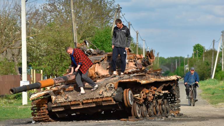 Residentes de la localidad de Zahaltsi, cercana a Kiev, inspeccionan un tanque quemado. Foto: EFE