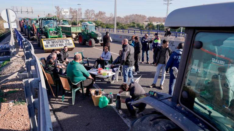 Payeses recuperando fuerzas tras pasar la noche en los accesos al Port, el martes día 13. Foto: Marc Bosch