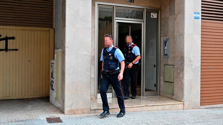 Dos mossos d’esquadra saliendo del edificio donde se cometió el crimen. Foto: Alfredo González/DT