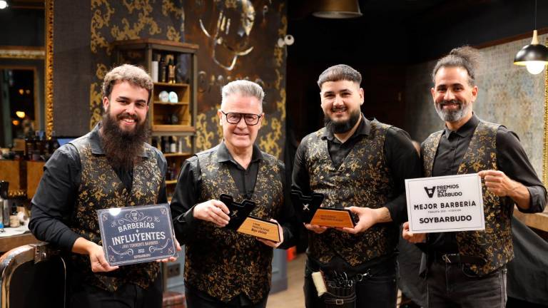 Javi Torrente, junto al equipo de su barbería, posa con los trofeos que le acreditaron en el certamen ‘Soy Barbudo’. foto: alba mariné
