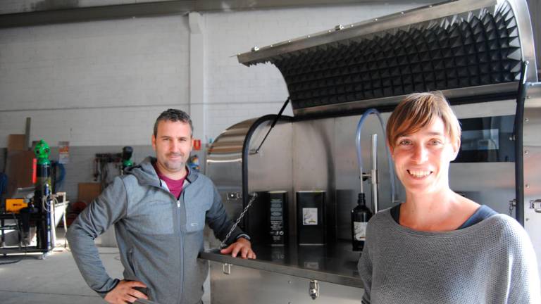 Ivan Samaniego y Jessica Pros, en su taller, junto a la primera generación de molinos de aceite portátiles. Fotos: Cedidas