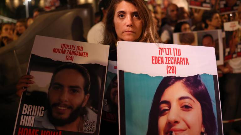 Orin Gan sostiene una imagen de su hija Eden Zecharya, que fue secuestrada por Hamás, durante una protesta para pedir la liberación de las personas secuestradas por Hamás. Foto: EFE/EPA/NEIL HALL