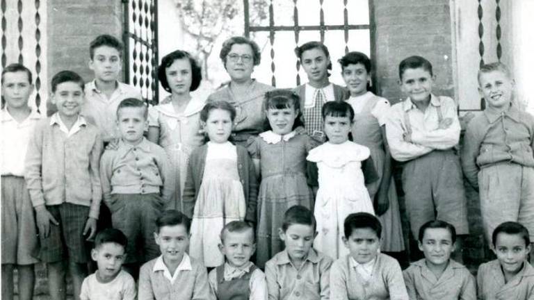 La maestra Rosa Miquel con alumnos de la escuala del Papiolet (Sant Jaume dels Domenys) en la década de los 50. FOTO: XARXA ARXIUS COMARCALS
