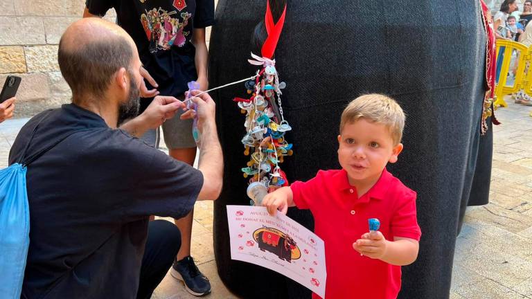 Un nen mostrant el diploma i el xupa-xup rebuts després d’entregar el seu xumet a la Mulassa. FOTO: Alfredo González